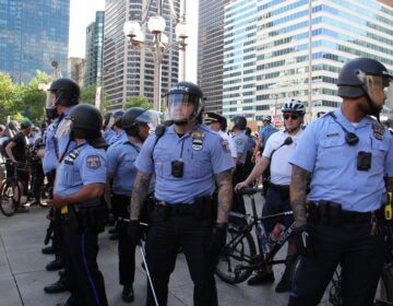 Police, some wearing body cameras, guard the Municipal Services Building during protests on May 30, 2020. (Emma Lee/WHYY)
