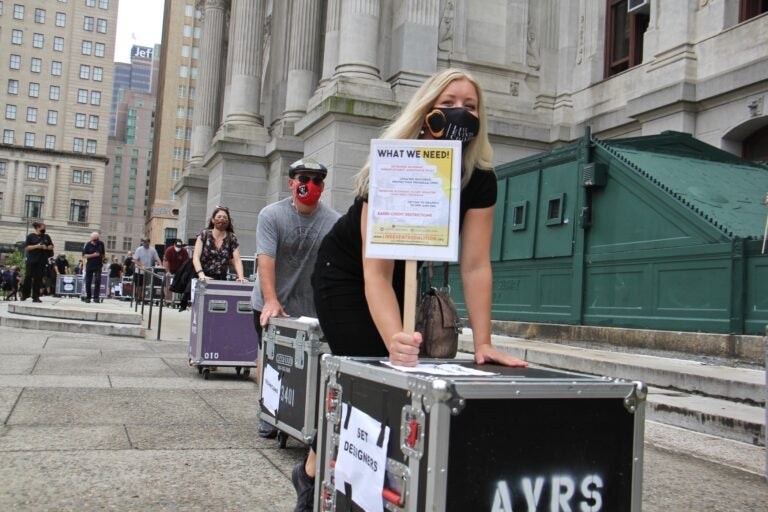 Members of the Live Events Coalition push roadie cases around City Hall to draw attention to their plight. (Emma Lee/WHYY)
