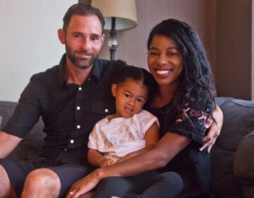 Aria Valentina Riso in between her mom, Chelsie DeSouza and dad, Vincent Riso at their home in South Philadelphia. (Kimberly Paynter/WHYY)