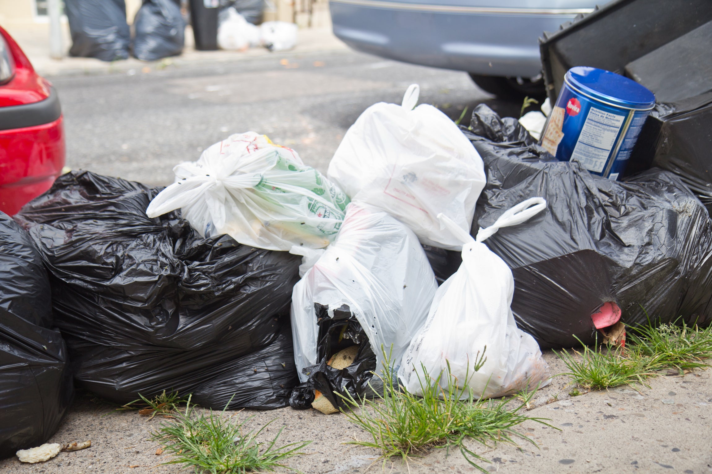 Heap of plastic trash bags on curb waiting for sanitation pickup