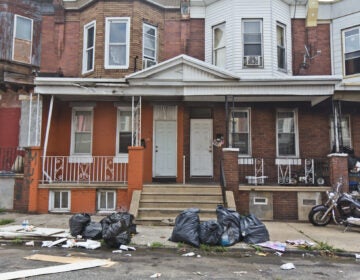 Bagged up trash sit outside Philly homes