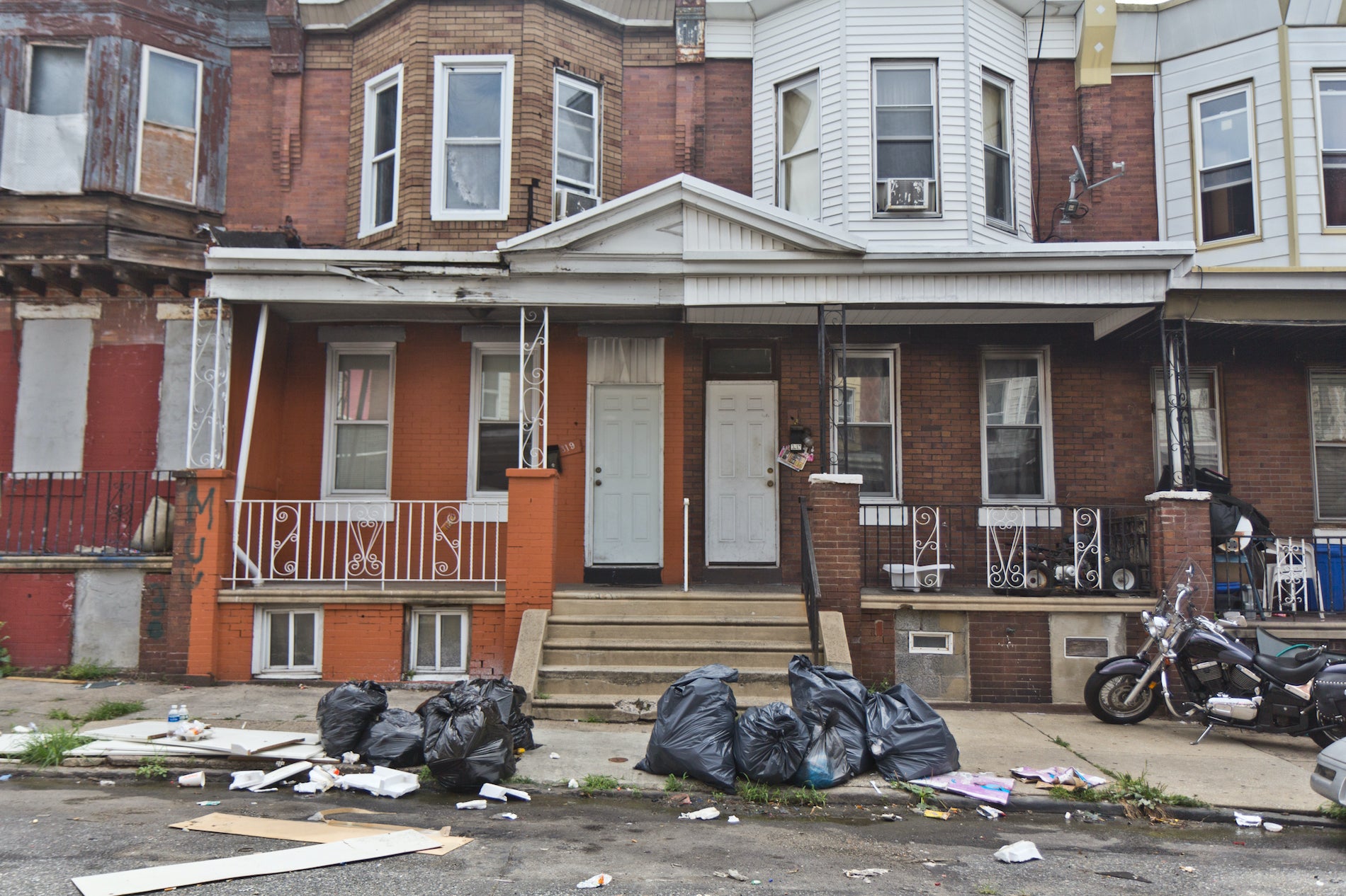 Heap of plastic trash bags on curb waiting for sanitation pickup