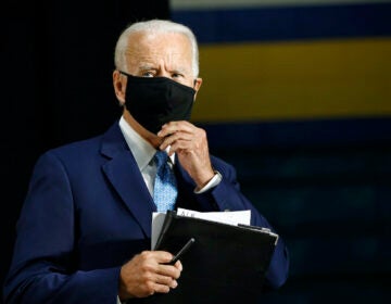 Democratic presidential candidate, former Vice President Joe Biden puts on a face mask to protect against the spread of the new coronavirus as he departs after speaking at Alexis Dupont High School in Wilmington, Del., Tuesday, June 30, 2020. (AP Photo/Patrick Semansky)