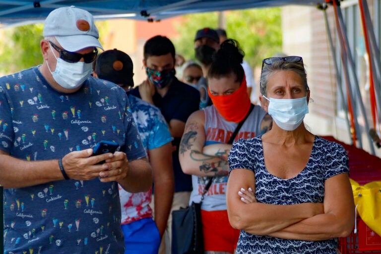 People waiting in line to enter a grocery store wear protective masks, Friday, July 3, 2020, in McCandless, Pa. Gov. Tom Wolf's more expansive mask order issued last week as the coronavirus shows new signs of life in Pennsylvania has been met with hostility from Republicans objecting to the Democrat's use of power or even to wearing a mask itself. (AP Photo/Keith Srakocic)