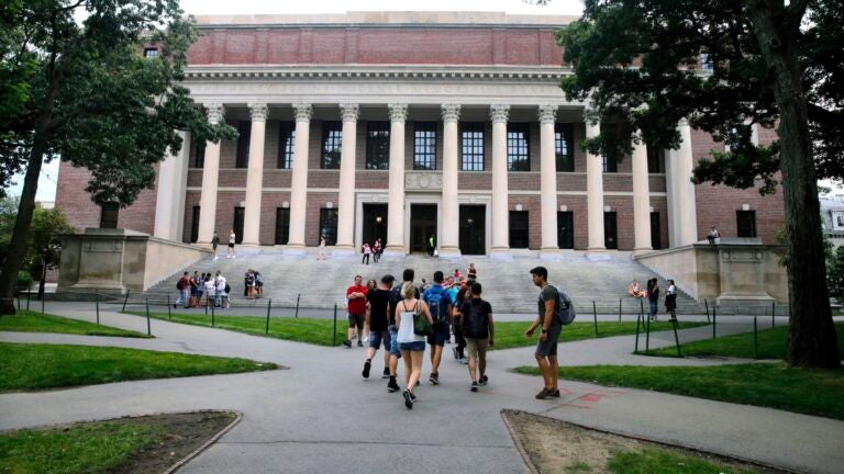 In this Aug. 13, 2019 file photo, students walk near the Widener Library in Harvard Yard at Harvard University in Cambridge, Mass. The Ivy League school announced Monday, July 6, 2020, that as the coronavirus pandemic continues its freshman class will be invited to live on campus this fall, while most other undergraduates will be required learn remotely from home. (AP Photo/Charles Krupa, File)