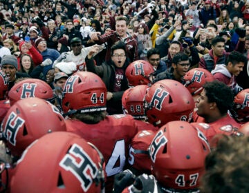 Harvard players, students and fans celebrate a win over Yale after an NCAA college football game at Fenway Park in Boston, Saturday, Nov. 17, 2018.  Harvard defeated Yale 45-27. (AP Photo/Charles Krupa)