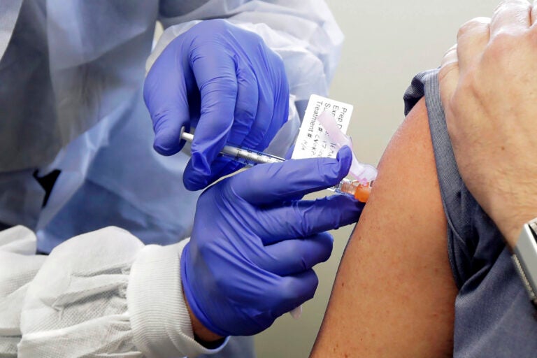 In this March 16, 2020, file photo, a subject receives a shot in the first-stage safety study clinical trial of a potential vaccine by Moderna for COVID-19, the disease caused by the new coronavirus, at the Kaiser Permanente Washington Health Research Institute in Seattle. (AP Photo/Ted S. Warren)