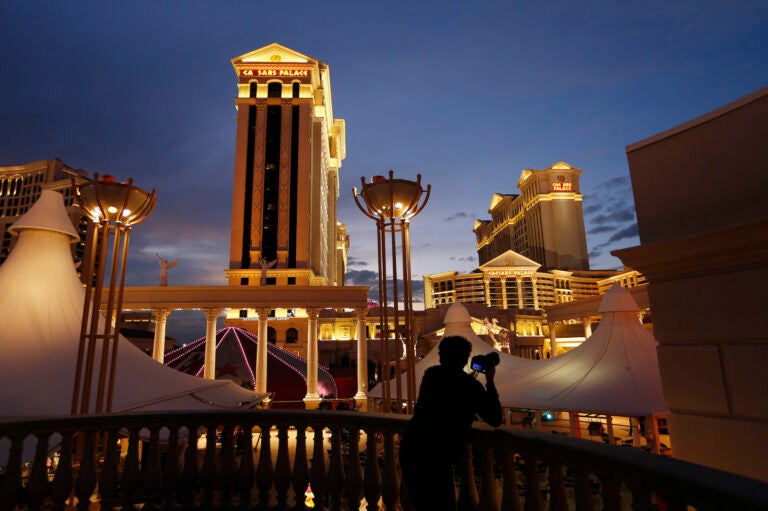 In this Jan. 12, 2015, file photo, a man takes pictures of Caesars Palace hotel and casino in Las Vegas. (AP Photo/John Locher)