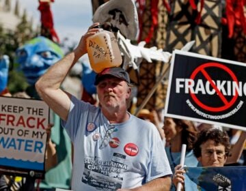 In this Sept. 20, 2012, file photo, Ray Kemble, of Dimock, Pa., holds a jug of his well water on his head while marching with demonstrators against hydraulic fracturing outside a Marcellus Shale industry conference in Philadelphia. (AP Photo/Matt Rourke, File)