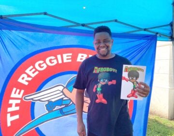 Comic book author Reggie Byers was selling copies of his latest book, 'AFROBOY AND PUFFGIRL' at the street fair in Media. (Zachariah Hughes/WHYY)