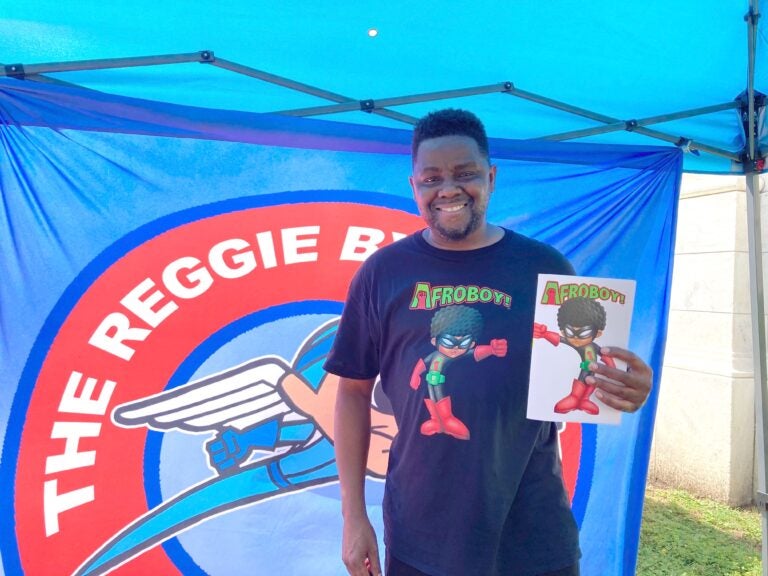 Comic book author Reggie Byers was selling copies of his latest book, 'AFROBOY AND PUFFGIRL' at the street fair in Media. (Zachariah Hughes/WHYY)