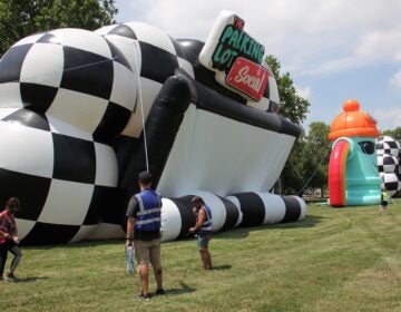 Workers set up for Parking Lot Social, a series of drive-in shows taking place at the Philadelphia Navy Yard. (Emma Lee/WHYY)