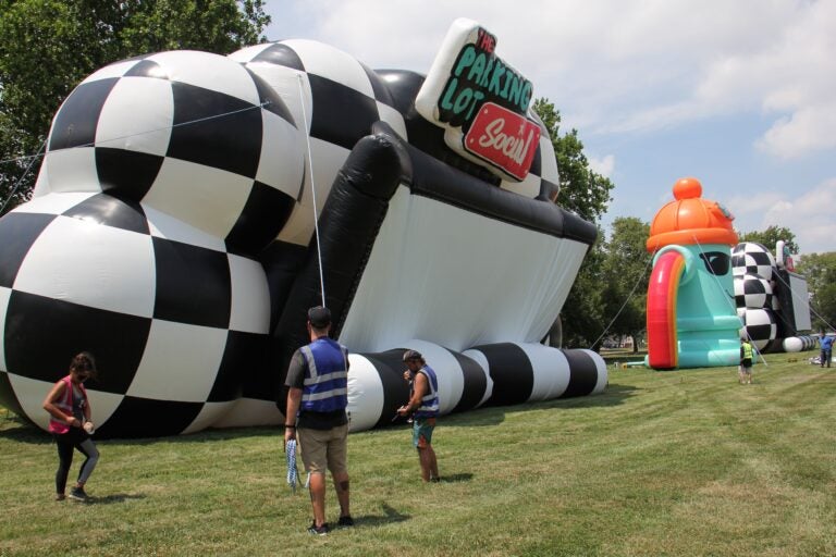 Workers set up for Parking Lot Social, a series of drive-in shows taking place at the Philadelphia Navy Yard. (Emma Lee/WHYY)