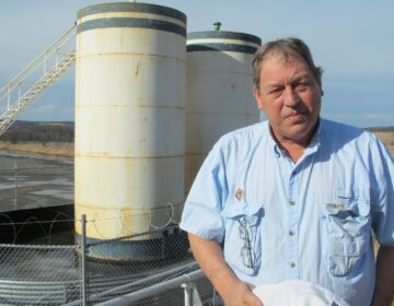 Jim Barrett stands next to a wellpad on his farm in Bradford County. He says Chesapeake Energy, which drilled four natural gas wells on his land, is cheating him out of royalty money. He is part of a class-action lawsuit against the company, which is separate from a case involving Chesapeake that's being pursued by the state Attorney General. (Marie Cusick/StateImpact Pennsylvania)