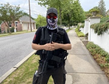 A man dressed in all black wore a tactical vest and carried an AR-15-style rifle