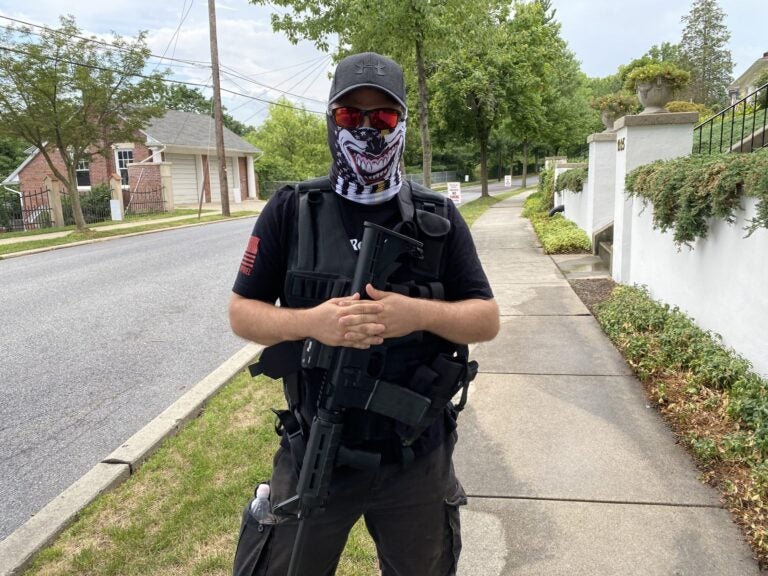 A man dressed in all black wore a tactical vest and carried an AR-15-style rifle