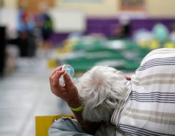 An evacuee lies on a cot at an evacuation shelter for people with disabilities in Stuart, Fla., in preparation for Hurricane Dorian on Sept. 1, 2019. Now, with the pandemic raging, officials across the South are trying to adjust their evacuation and shelter plans. (Gerald Herbert/AP Photo)