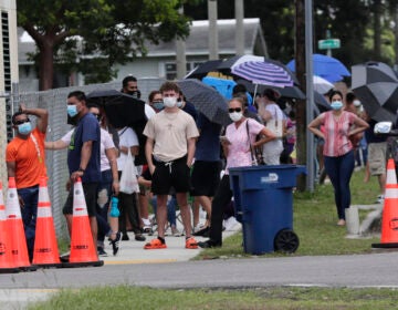 People wait in line outside of a COVID-19 testing site in Florida.