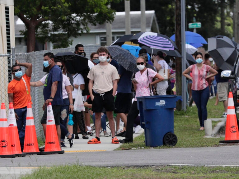 People wait in line outside of a COVID-19 testing site in Florida.