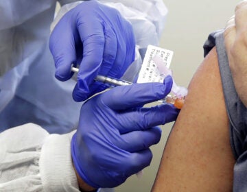 A patient receives a shot in a clinical trial for a potential coronavirus vaccine. U.S. intelligence officials say Russian hackers are attempting to break into U.S. health care organizations working on a vaccine.