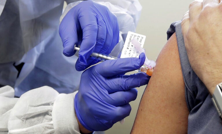 A patient receives a shot in a clinical trial for a potential coronavirus vaccine. U.S. intelligence officials say Russian hackers are attempting to break into U.S. health care organizations working on a vaccine.