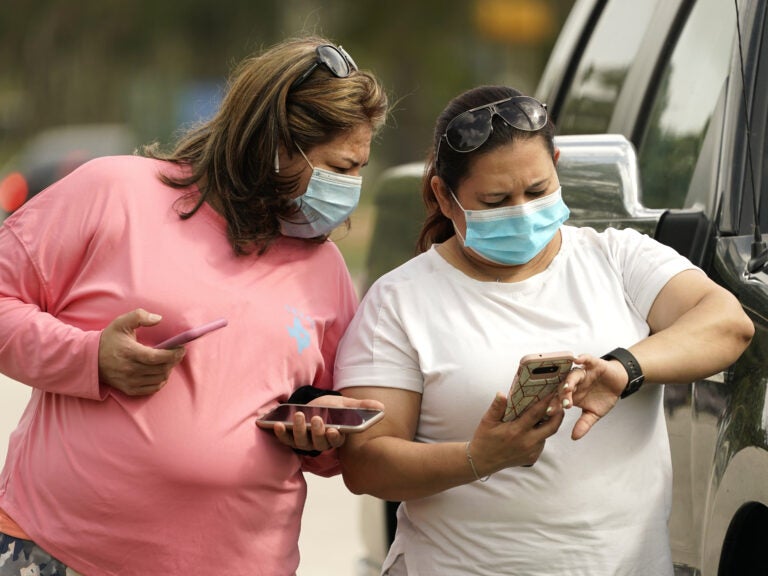 Women wear masks in Houston on Wednesday. Harris County requires any business providing goods or services to require all employees and visitors to wear face coverings in areas of close proximity to co-workers or the public, at least through Aug. 26.