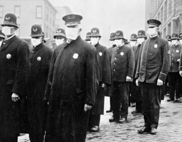 Policemen in Seattle, Washington, wearing masks made by the Red Cross, during the influenza pandemic, December 1918. (National Archives)