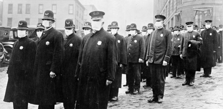 Policemen in Seattle, Washington, wearing masks made by the Red Cross, during the influenza pandemic, December 1918. (National Archives)