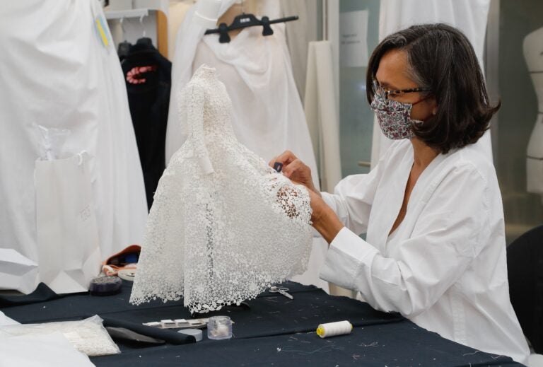 An employee sews a miniature dress in Dior's sewing workshop in Paris on July 4. This year Dior created a miniature collection for its haute couture show and presented it as a film. (Francois Guillot/AFP via Getty Images)