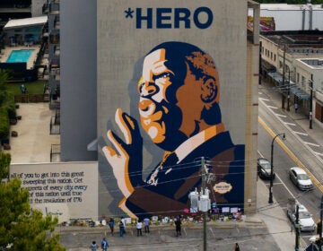 Mourners pay their respects at a mural of Rep. John Lewis painted on a building in Atlanta. The civil rights icon and congressman died on Friday.