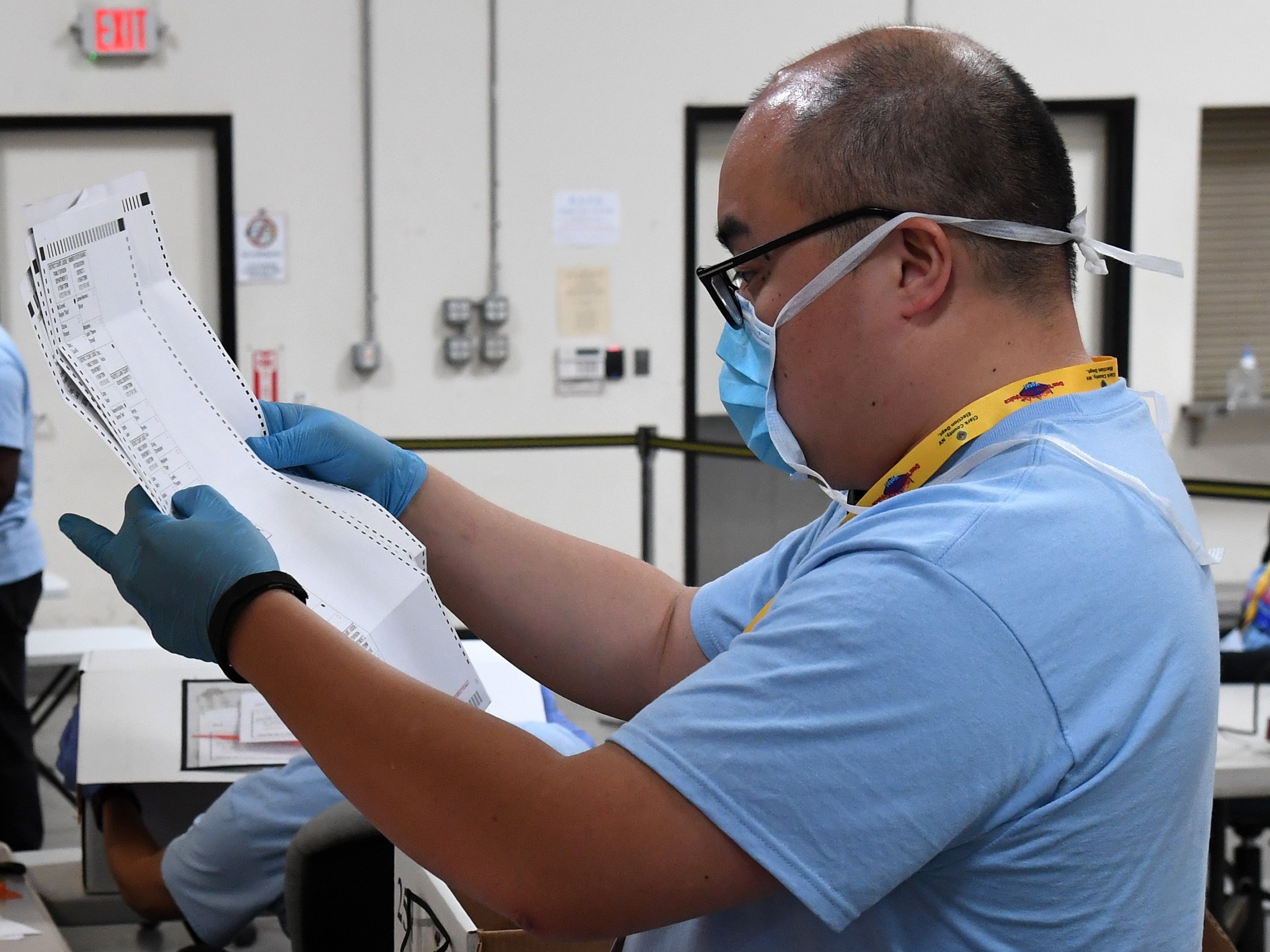 A Clark County election worker scans mail ballots following Nevada's June election.