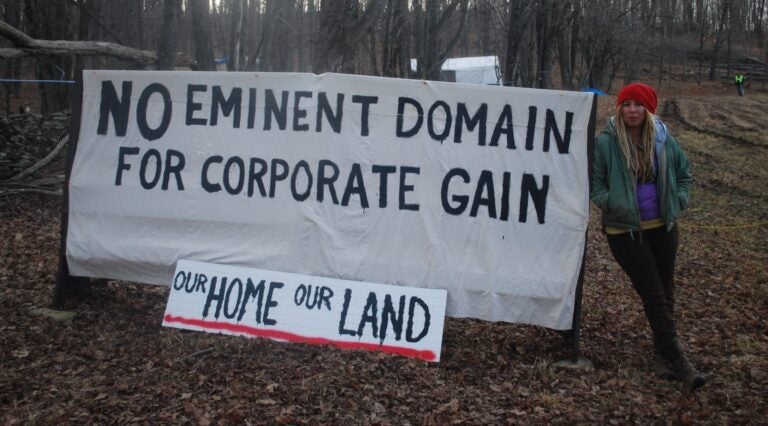 Megan Holleran stands by a sign on her family's land, March, 2016. The Hollerans lost their court battle to save their maple trees from eminent domain seizure. The trees were cut to make way for the Constitution Pipeline, which had been stalled amid legal battles until Williams withdrew the project in February. (Jon Hurdle / StateImpact PA)