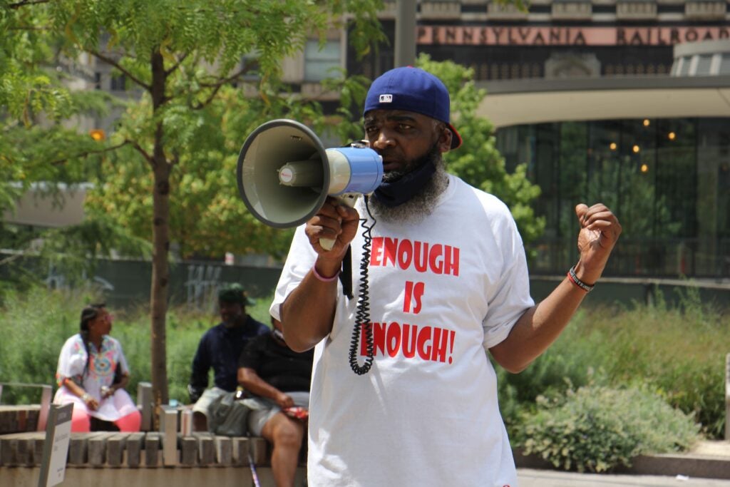 Ikey Raw speaks into a megaphone at a rally