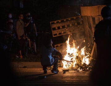 A protester in Kenosha lights some debris on fire on Aug. 26, 2020. (Angela Major/WPR)