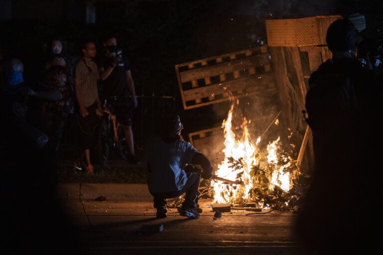 A protester in Kenosha lights some debris on fire on Aug. 26, 2020. (Angela Major/WPR)