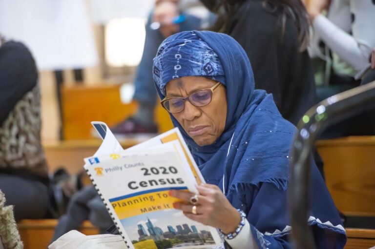 Ruqayya Ali of Center City peruses Philly Counts census literature during the Philly Counts 2020 summit at South Philadelphia High School. (Jonathan Wilson for WHYY)