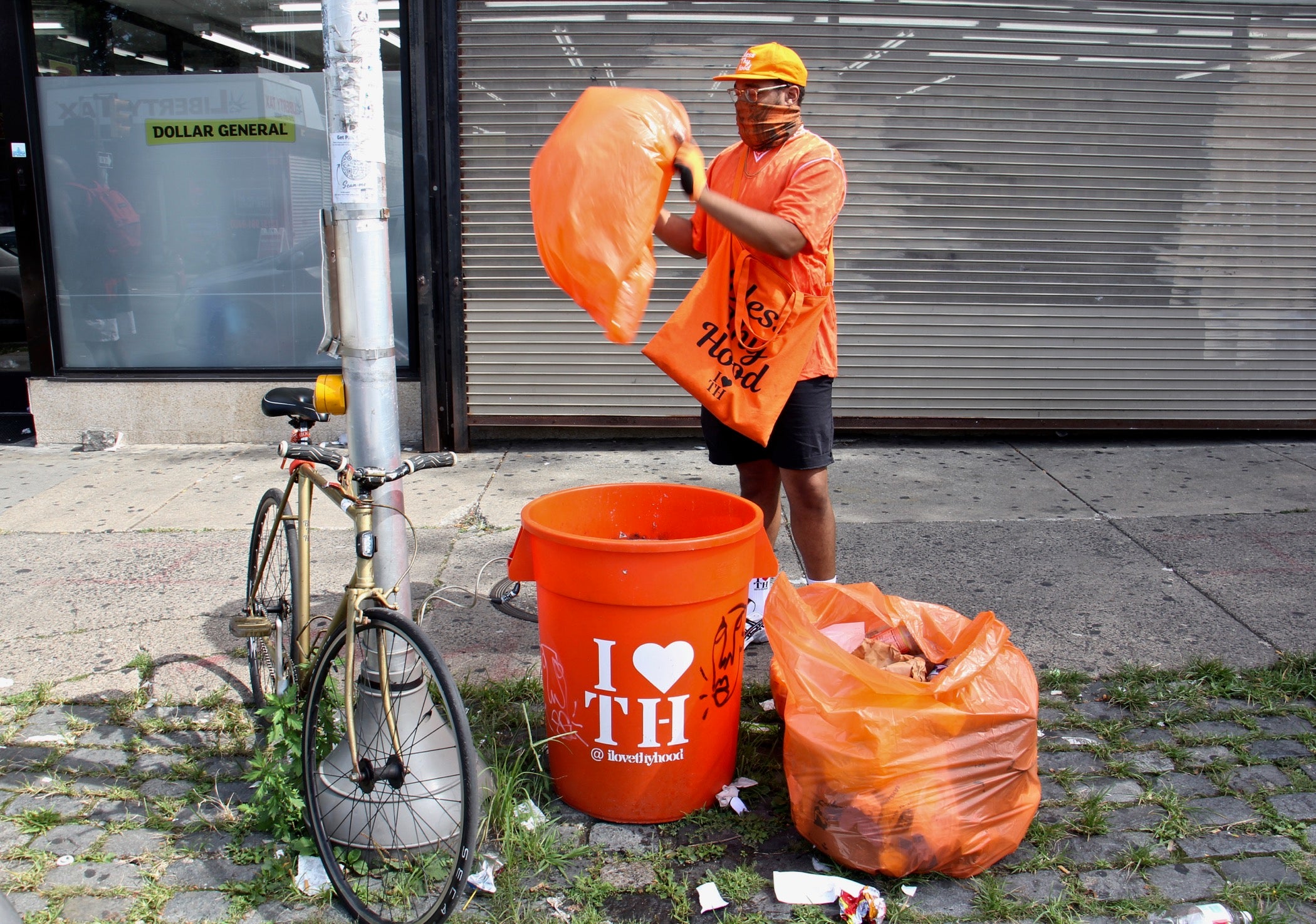 Matthew George changes the bag at his I Love Thy Hood can outside the Dollar General on Chelten Avenue.