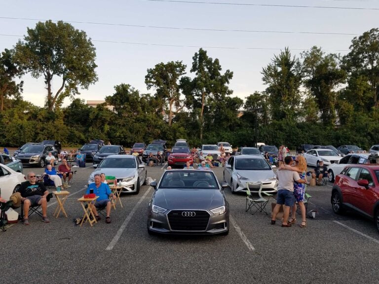 People and cars gathered at a parking lot turned into a drive-in during the coronavirus pandemic