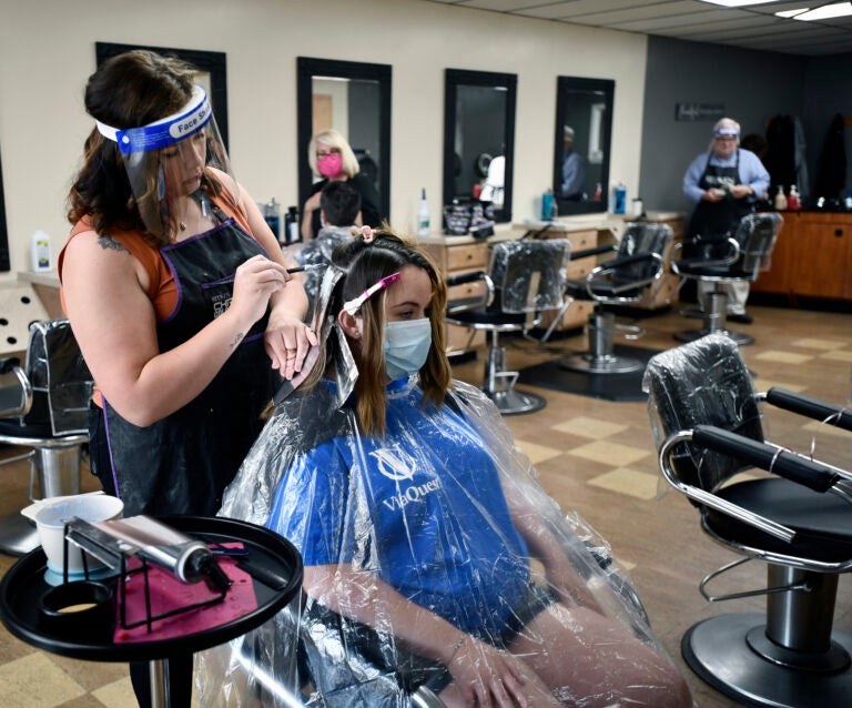 Salon Vizions stylist Michaela Slayton colors Paulette Fultz hair with Personal Protection Equipment on and Fultz wears a mask with a disposable gown on in Johnstown, Pa, Friday, June 5, 2020. (Todd Berkey/The Tribune-Democrat via AP)