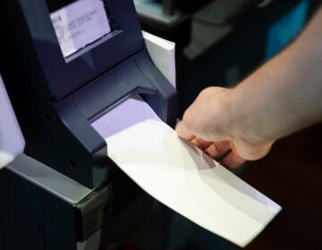 In this June 13, 2019 file photo, an Investigator with the Office of the City Commissioners, demonstrates the ExpressVote XL voting machine at the Reading Terminal Market in Philadelphia. (AP Photo/Matt Rourke)