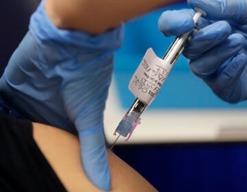 Volunteer is injected with the vaccine as part of an Imperial College vaccine trial, at a clinic in London, Wednesday, Aug. 5, 2020. Imperial College is working on the development of a COVID-19 vaccine. (AP Photo/Kirsty Wigglesworth)