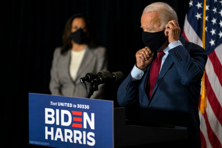 Democratic presidential candidate former Vice President Joe Biden joined by his running mate Sen. Kamala Harris, D-Calif., replaces his face mask after speaking at the Hotel DuPont in Wilmington, Del., Thursday, Aug. 13, 2020. (AP Photo/Carolyn Kaster)