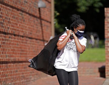 Oyeronke Popoola, a 17-year-old freshman from Raleigh, carries some of her belongings as she and other students leave campus following a cluster of COVID-19 cases at The University of North Carolina in Chapel Hill, N.C., Tuesday, Aug. 18, 2020. (AP Photo/Gerry Broome)