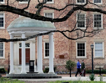 In this Wednesday, March 18, 2020, file photo, people remove belongings on campus at the University of North Carolina in Chapel Hill, N.C., amid the coronavirus pandemic. (AP Photo/Gerry Broome)