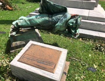 A statue of a Confederate soldier in front of a courthouse in Lake Charles, La., lies on the ground Thursday Aug. 27, 2020 after being toppled when Hurricane Laura ripped through the area. Earlier this month parish officials voted to keep the statue, called the South’s Defenders Monument, in its place. (AP Photo/Melinda Deslatte)