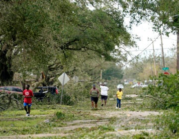 People survey the damage to their neighborhood on Thursday, Aug. 27, 2020, in Lake Charles, La., in the aftermath of Hurricane Laura. (AP Photo/Gerald Herbert)