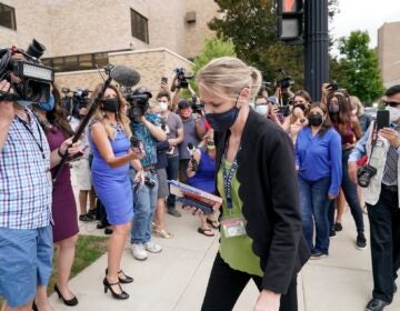 Kasey Morgan, a public information officer for the Lake County Court, walks away from reporters outside the Lake County courthouse following the extradition hearing for Kyle Rittenhouse Friday, Aug. 28, 2020, in Waukegan, Ill. (AP Photo/Morry Gash)