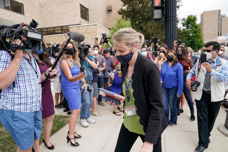 Kasey Morgan, a public information officer for the Lake County Court, walks away from reporters outside the Lake County courthouse following the extradition hearing for Kyle Rittenhouse Friday, Aug. 28, 2020, in Waukegan, Ill. (AP Photo/Morry Gash)