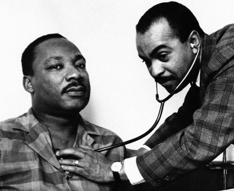 Dr. Walter Lomax, a Philadelphia physician, tending to Dr. Martin Luther King, Jr. in his hotel room bed in Philadelphia, Feb. 10, 1968. (AP Photo)