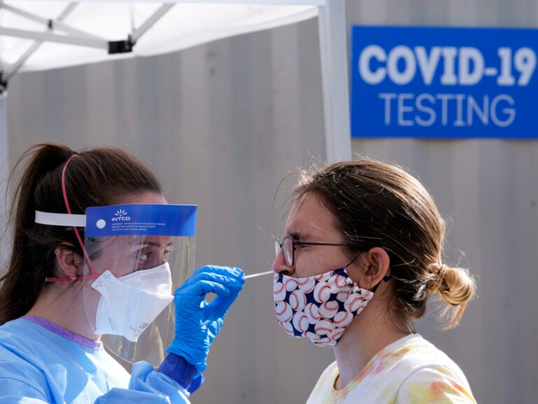 A woman is tested for COVID-19 at a walk-up testing site